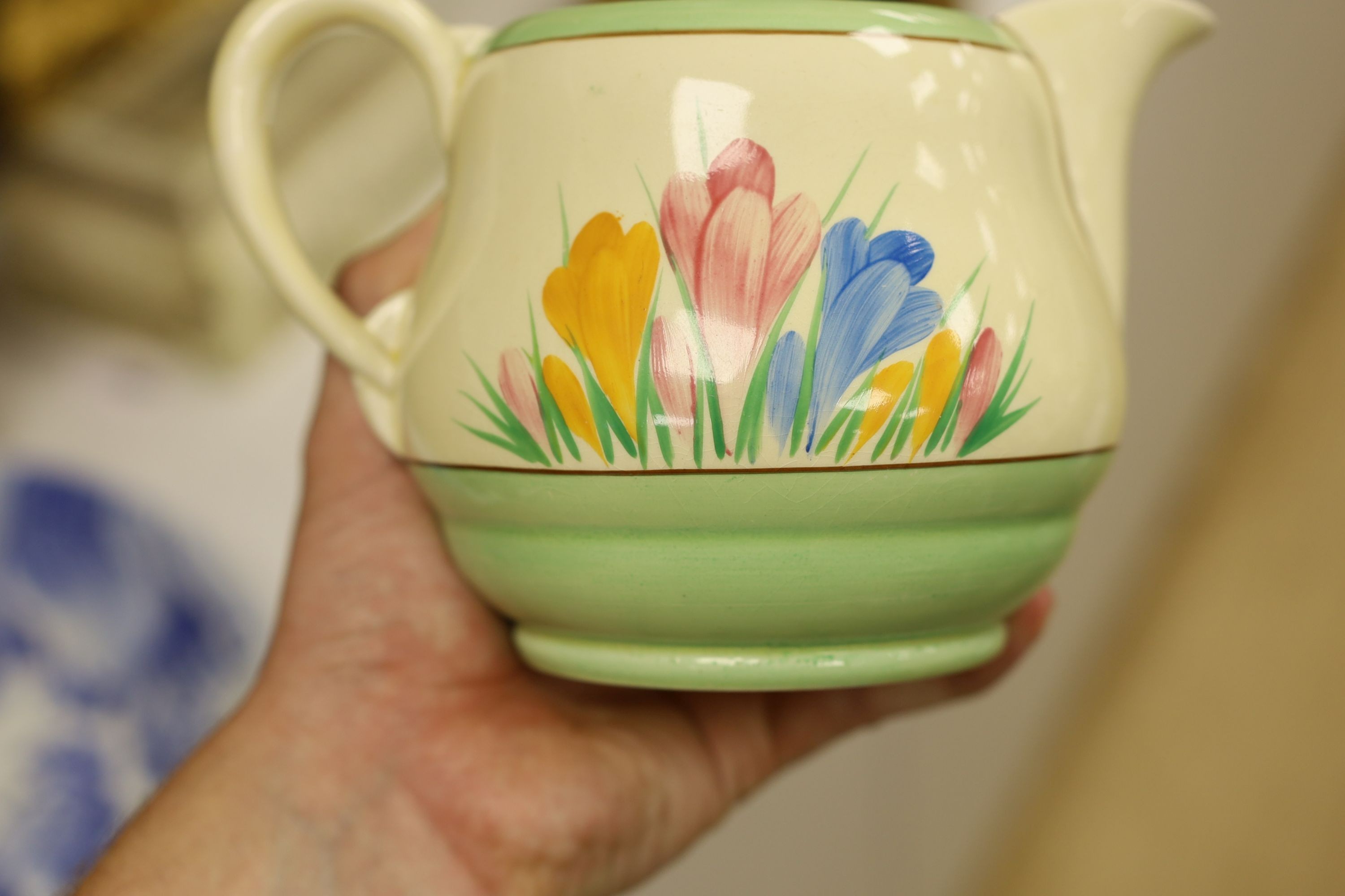 A Clarice Cliff crocus design milk jug and a Bizarre patterned side plate, jug 11.5 cms high